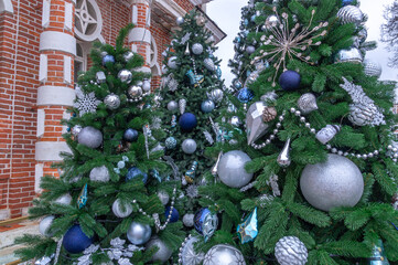 Christmas decorations on a snow-covered Christmas tree in Tsaritsyno Park. Against the background of Christmas tree toys. Festive decorations on Christmas Eve. Winter holidays in Moscow.