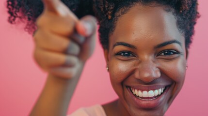 Smiling woman in a studio pointing with her finger, conveying excitement against a vibrant background, ideal for advertising or promotional use