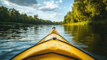 Kayaking on a calm river through a forest, with only the bow of the yellow kayak visible in the foreground.
