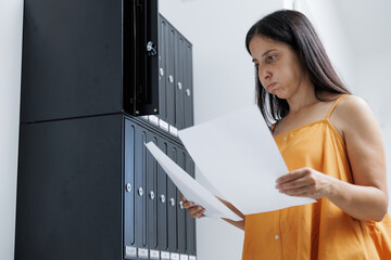 The woman looks at the correspondence in the mailbox at home and receives the long-awaited letters,...