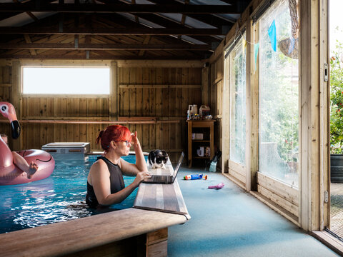 Parent home working from an indoor swimming pool in the garden
