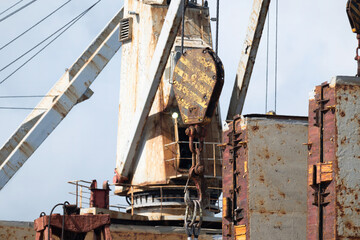 A rusty hook of the deck crane is used for loading many containers to the holds of the ship.