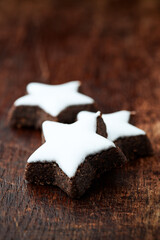 Christmas cookies (cinnamon stars) on dark background. Close up.	