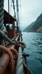 Obraz premium A boat is sailing in the ocean with the sun setting in the background