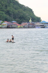 three men climbed onto a piece of wood floating drifting in the river