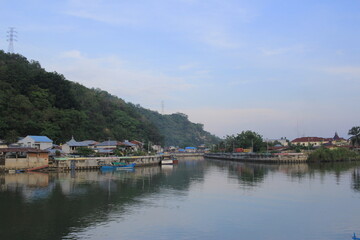 Fototapeta premium rows of houses in the fishing village at the mouth of the river at the foot of the hill