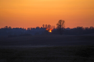 Bright sunset over the fields. Agricultural landscape in eastern Lithuania.