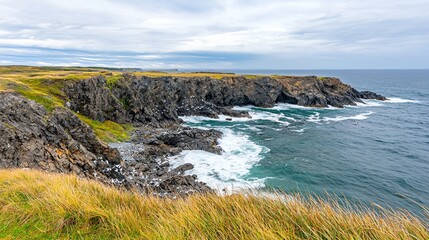 Rugged coastline with crashing waves and grassy cliffs.