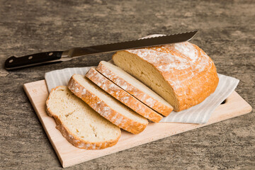 Assortment of freshly sliced baked bread with napkin on rustic table top view. Healthy unleavened bread. French bread slice