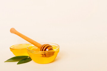 Honey in jar with leaves and honey dipper on colored background top view with copy text