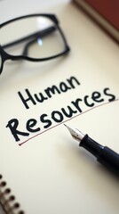 Human resources concept with text, fountain pen, and glasses