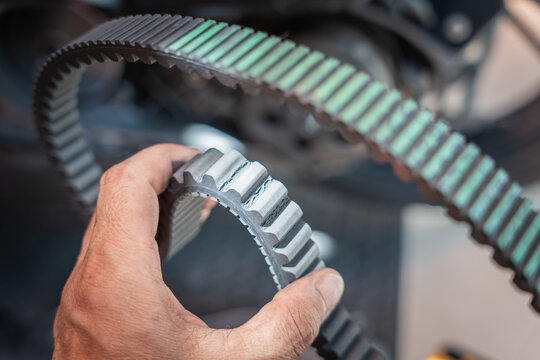  Motorcycle mechanic check the condition of motorcycle transmission belt or Drive belt ,working at garage, maintenance and repair motorcycle concept