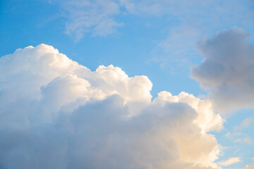 Fluffy white clouds gently floating in a clear blue sky during a sunny afternoon