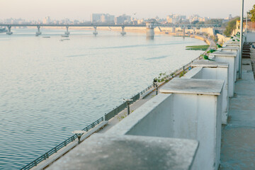 Obraz premium The rose-ringed parakeet (Psittacula krameri) is a green parrot that is commonly found in Ahmedabad. The photo has Sabarmati river in the background