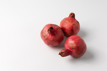 Three ripe pomegranates on a white background