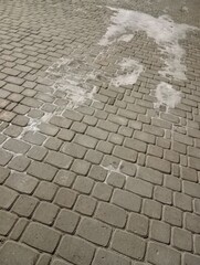 stone pavement. The paving stones are covered with ice. Sidewalk in the cold season