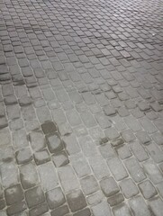 The paving stones are covered with ice. Sidewalk in the cold season
