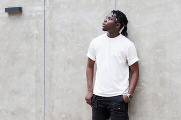 Candid of African man model with dreadlocks hairstyle wearing white t-shirt standing at the background