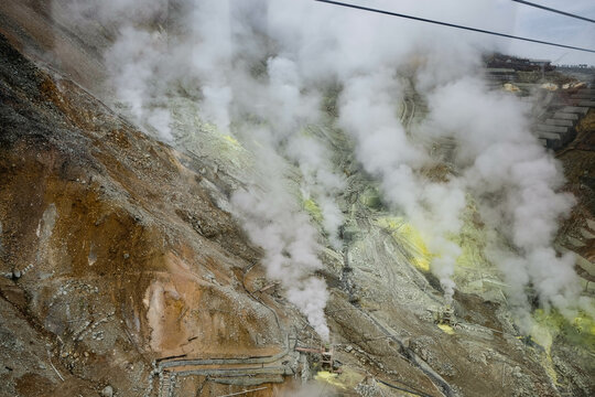 Owakudani, Japan- 29 Oct 2024: the volcano mountain with smoke and cable cars along the mountain with different colors rocks in yellow, brown and orange view from ropeway
