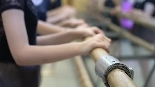 the hands of a ballerina on a ballet bar