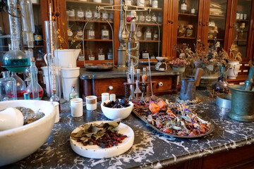 Chemistry flasks with liquids, herbs of medicinal plants in an old pharmacy