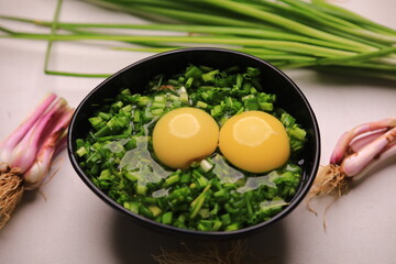 bowl of egg yolks isolated on white background, top view with green vegetables.close up image of two eggs yolk in a bowl are one of the food ingredients on the restaurant table in the kitchen .