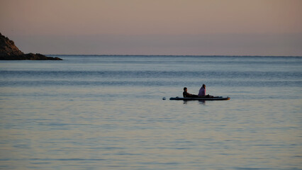 Naklejka premium Sunset on the Côte d'Azur with people on paddle enjoying the sea