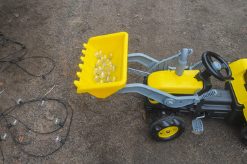 a child boy on a wheeled bulldozer tractor electrical work bulbs and light, photo without filters