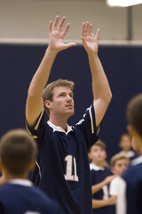 Fototapeta premium Coach instructs young athletes during practice in a gymnasium setting