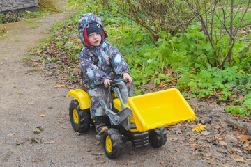 a child boy on a wheeled bulldozer tractor, photo without filters