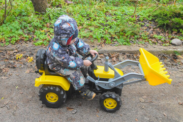 a child boy on a wheeled bulldozer tractor, photo without filters