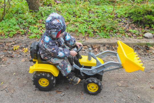 a child boy on a wheeled bulldozer tractor, photo without filters