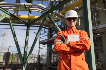 Engineer with cross arm pose at oil refinery site