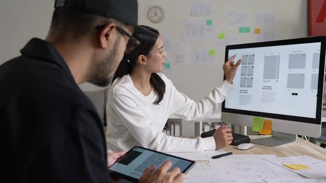 UX UI designers discussing and brainstorming on wireframes for a website and mobile app prototype, in the concept of website and mobile application design concept.