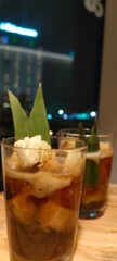 two glasses of a refreshing beverage, likely a traditional Indonesian drink called Es Kelapa Muda.