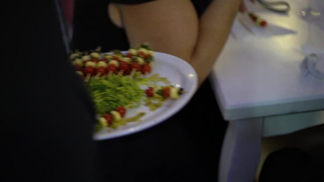 innkeeper offers some cappressa skewers at a wedding party