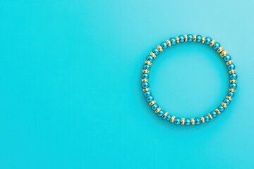  Colorful Beaded Bracelet Displayed on Vibrant Blue Background in a Minimalist Composition Highlighting Handmade Jewelry and Artistic Craftsmanship