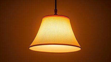 Obraz premium Soft, focused light from a ceiling lamp fixture in a dark room, creating a calm, comforting ambiance.