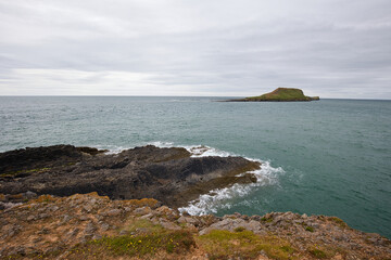 View of Rhossili Bay on the small island of Worm's Head on the Welsh coast.