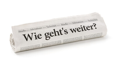 Zeitungsrolle mit der Überschrift Wie gehts weiter?