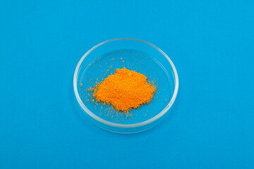 Tartrazine powder in Petri dish. Synthetic lemon yellow azo dye. It serves as dye for wool and...