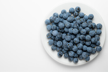Plate of Fresh Blue Plums on White Background
