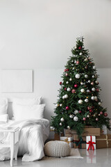 Interior of festive bedroom with comfortable bed and Christmas tree