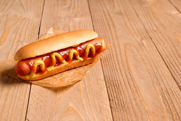 Tasty hot dog on wooden background