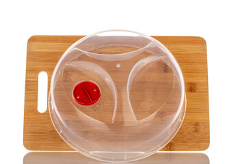 One bamboo kitchen board and plastic lid for microwave, macro, isolated on white background.