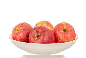 Several red apples on a ceramic plate, macro, isolated on a white background.