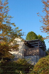 Charming and Vibrant Autumn Landscape Featuring a Rustic House Against a Clear Blue Sky