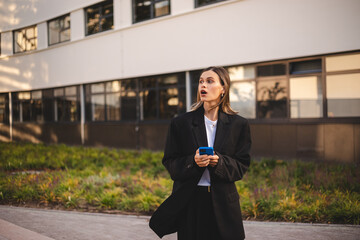 Business short hair woman wear jacket suit, standing outdoor near office, looking, waiting or...
