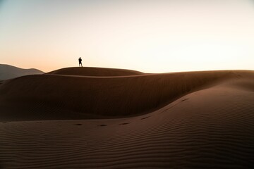 Silhouette shot of a man standing on the Longotoma dunes watching sunset in Valparaiso Region, Chile