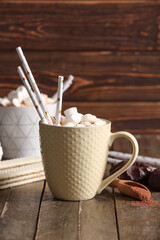 Cups of hot cocoa with marshmallows and sweet waffles on wooden background